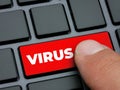 Close up finger pressing red virus key on computer keyboard Royalty Free Stock Photo