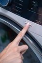 Close up of a finger pressing the start button on a modern washing machine control panel Royalty Free Stock Photo