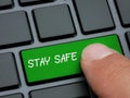 Close up finger pressing stay safe key on computer keyboard prevention message concept