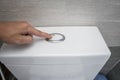 Close up of finger pushing a flush toilet button for cleaning a toilet. Royalty Free Stock Photo