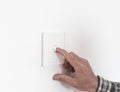 Close up of finger is turning on or off on light switch. Copy space. Royalty Free Stock Photo