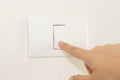 Close up of finger turning off on light switch on wall Royalty Free Stock Photo
