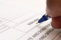 Close up of Fingers holding a pen and signing a income tax form. Royalty Free Stock Photo