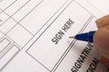 Close up of Fingers holding a pen and signing a income tax form. Royalty Free Stock Photo