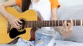 Close up fingers playing guitar strings