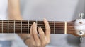 Close up fingers playing guitar strings