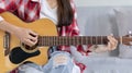 Close up fingers playing guitar strings