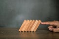 Close-up fingers prevent the wooden block from falling domino Royalty Free Stock Photo