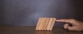 Close-up fingers prevent the wooden block from falling domino Royalty Free Stock Photo