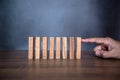 Close-up fingers prevent the wooden block jenga game stick from falling domino