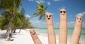 Close up of fingers with smiley faces on beach Royalty Free Stock Photo