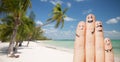 Close up of fingers with smiley faces on beach Royalty Free Stock Photo