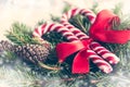 Close up of a fir tree and candy cones tied with a red bow over an old white wood background. Christmas decoration background. Vin Royalty Free Stock Photo