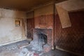 Close up of fireplace in derelict 1930s deco house, with wallpaper peeling off the wall. Rayners Lane, Harrow UK