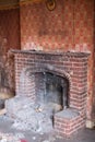 Close up of fireplace in derelict house, with wallpaper peeling off the wall. Rayners Lane, Harrow UK