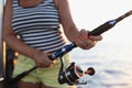 Close-up of fisherwoman holding spinning rod in her hands. Royalty Free Stock Photo