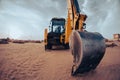 Close up fisheye abstract view of back hoe digger in contruction industry with dramatic cloudy background Royalty Free Stock Photo