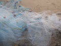 Close-up of a fishing net spread out on a sandy beach at sunset