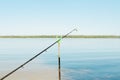 Close-up of fishing rod with bell on stand on lake outdoors. Summer fishing. Selective focus Royalty Free Stock Photo