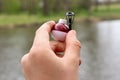 Close-up - fishing rod, line and red and white float in hand. River and forest in the background