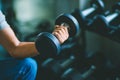 Close up of fit young hand caucasian big muscle in sportswear. Young man holding dumbbell during an exercise class in a gym Royalty Free Stock Photo