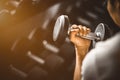 Close up of fit young hand caucasian big muscle in sportswear. Young man holding dumbbell during an exercise class in a gym. Royalty Free Stock Photo