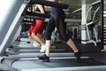 Fit young women running together on treadmill