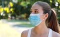 Close up fitness girl wearing surgical mask in the park looking to the side. Portrait of young sporty woman with protective mask Royalty Free Stock Photo