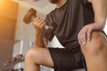 Close up fitness hand is working out to lift dumbbell. Healthy man is exercising in gym. Royalty Free Stock Photo