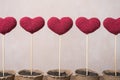 Close up of five crocheted hearts in peat glasses