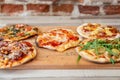 Close up of five pizzas on a wooden board on a wooden table Royalty Free Stock Photo