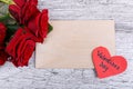 Close-up of five red roses on a gray background, with a paper heart and an envelope, the day of the holy Valentine. Royalty Free Stock Photo