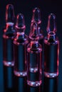 Close up of five transparent glass ampoules with liquid on table