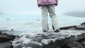 Close up Fjallsjokull glacier lagoon with person stands on iceberg. Wonderful glacier lagoon of FjallsÃÂ¡rlÃÂ³n in Iceland melts