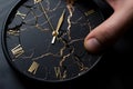 A close-up of flat black color clock on a man\'s hand breaking into pieces.