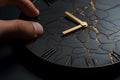 A close-up of flat black color clock on a man\'s hand breaking into pieces.