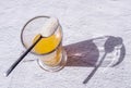 Collagen spoon and orange juice glass shadow concrete background. Sustainability, beauty and healthy living concept