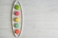 Close up. Flat lay. Colorful pastry french macarons lined up in a row on white plate. Copy space