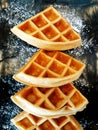 Close up flat lay of four waffles with icing sugar