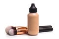 Close-up of flat makeup brush with liquid foundation tube on white