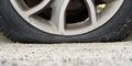 Close-up of Flat rear tire on car. The right rear broken weel. Damaged rear wheels on parking place Royalty Free Stock Photo