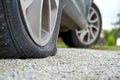 Close-up of Flat rear tire on car. The right rear broken weel. Damaged rear wheels on parking place Royalty Free Stock Photo