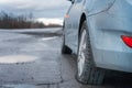 Close up Flat tire and blue car on the road after the rain waiting for repair Royalty Free Stock Photo