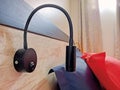 Close up of flexible wall lamp with switch at headboard of bed in bedroom. Decorative reading lamp. Electricity and home