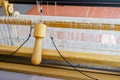 Close-up of a floor loom flying shuttle pull and warp threads and heddles for textile weaving Royalty Free Stock Photo