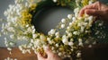 A close-up of the florist& x27;s skilled hands weaving delicate sprigs of baby& x27;s breath and buttery yellow flowers