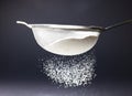 Close-up of flour sifting by sieve against black background, copy space