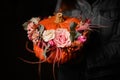 Close-up on flower arrangement in pumpkin on female hand. Decoration for thanksgiving day and halloween