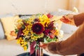 Close up of flower arrangement. Woman makes fall bouquet of sunflowers dahlias roses and zinnias in vase at home Royalty Free Stock Photo