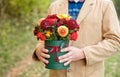 Close-up flower-box in man hands as a gift concept for wedding, birthday, event, celebration, flowers delivery, surprise